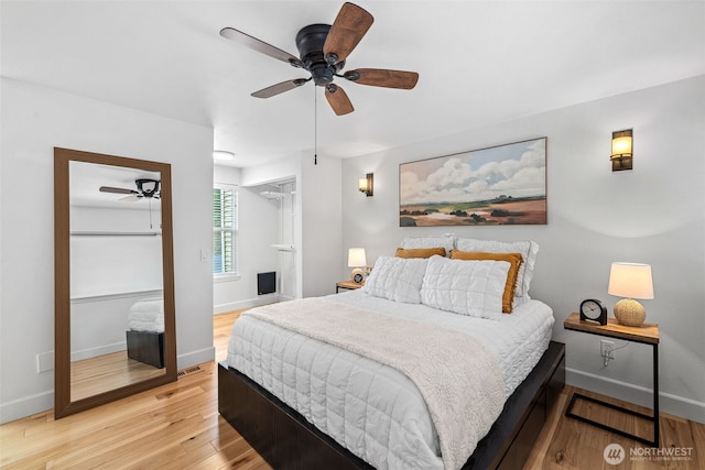 bedroom featuring baseboards, light wood-style floors, and ceiling fan