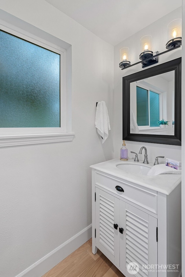 bathroom with vanity, baseboards, and wood finished floors