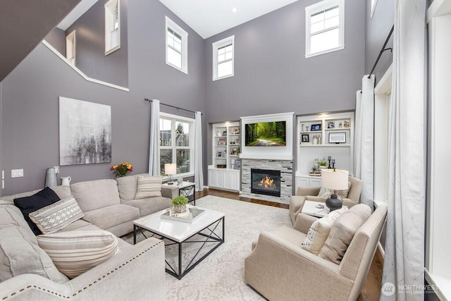 living area featuring a stone fireplace and wood finished floors