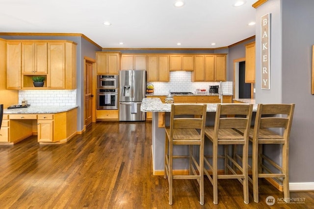 kitchen with light stone countertops, a peninsula, ornamental molding, dark wood-type flooring, and appliances with stainless steel finishes