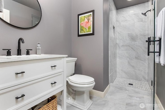 bathroom with baseboards, toilet, a stall shower, marble finish floor, and vanity