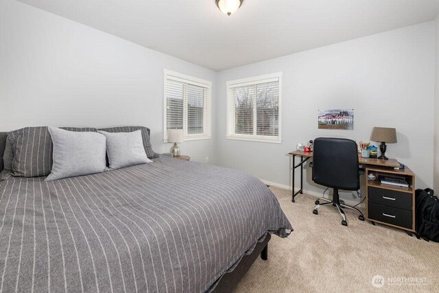 bedroom featuring light colored carpet and baseboards