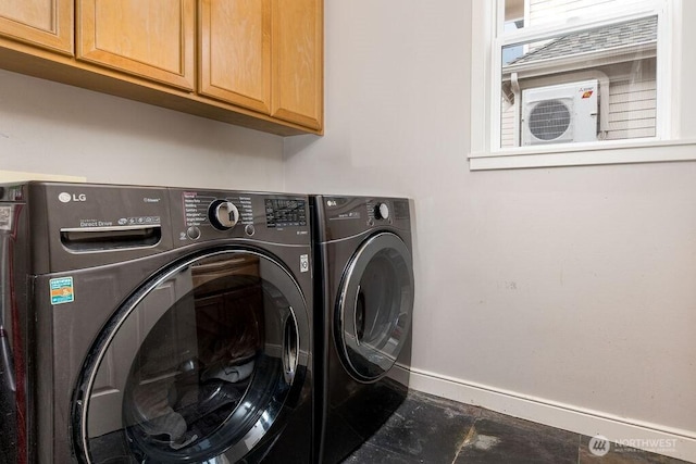 washroom with washer and dryer, baseboards, and cabinet space