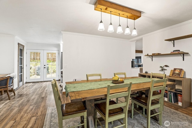 dining room with wood finished floors, crown molding, and french doors