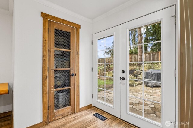 entryway featuring visible vents, baseboards, ornamental molding, french doors, and wood finished floors