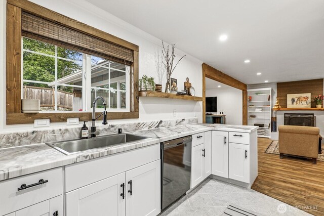 kitchen with a sink, recessed lighting, white cabinets, light countertops, and dishwasher