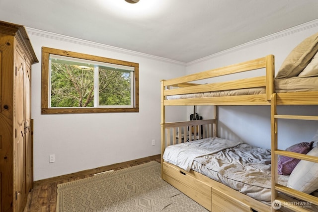 bedroom with wood finished floors, baseboards, and ornamental molding