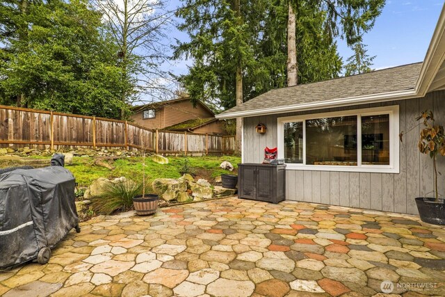 view of patio with area for grilling and fence