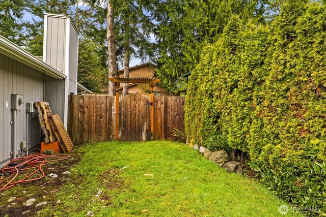 view of yard featuring fence and a pergola