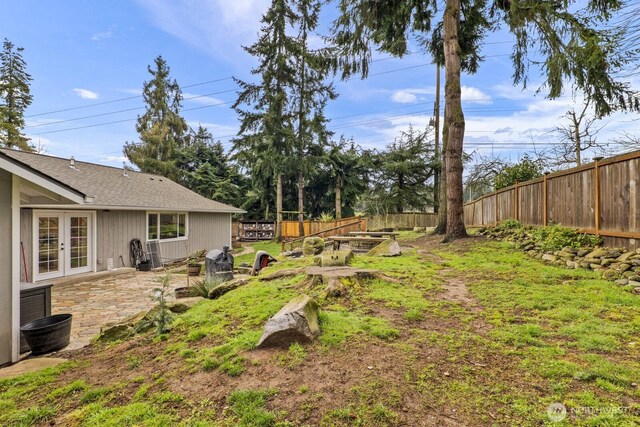 view of yard with a patio area, french doors, and a fenced backyard