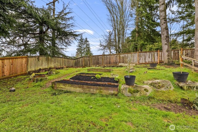 view of yard with a garden and a fenced backyard