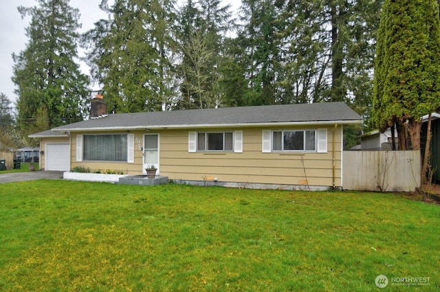 ranch-style home featuring driveway, a front lawn, fence, an attached garage, and a chimney