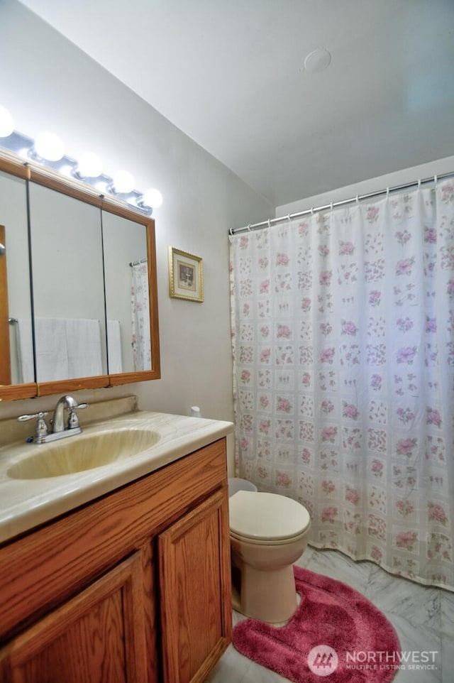 full bathroom featuring vanity, toilet, and marble finish floor