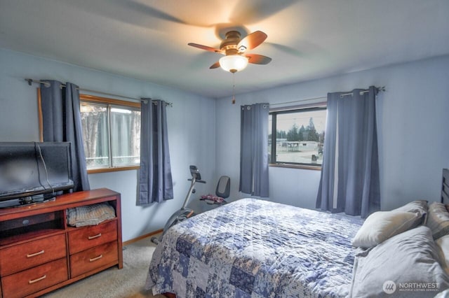 bedroom with multiple windows, a ceiling fan, baseboards, and carpet floors