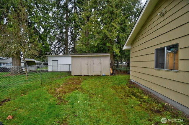 view of yard with an outbuilding, a shed, and fence