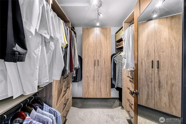 walk in closet featuring light colored carpet