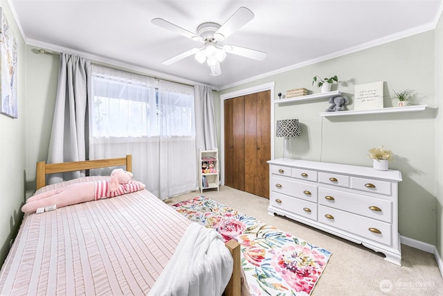 bedroom with ceiling fan, light colored carpet, a closet, and ornamental molding