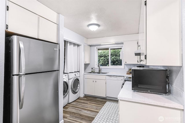 kitchen with a sink, wood finished floors, white cabinetry, freestanding refrigerator, and white dishwasher