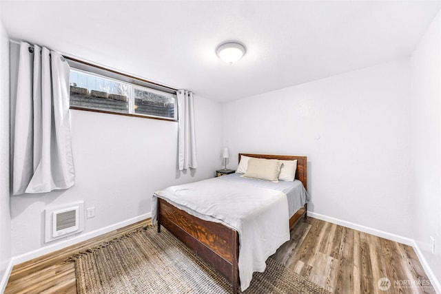 bedroom with baseboards and wood finished floors