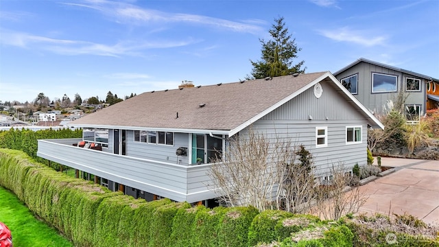 back of house featuring a patio, roof with shingles, and concrete driveway