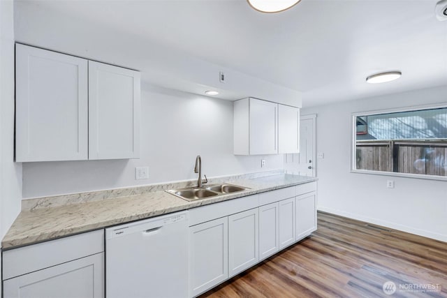 kitchen with dishwasher, light countertops, wood finished floors, white cabinets, and a sink