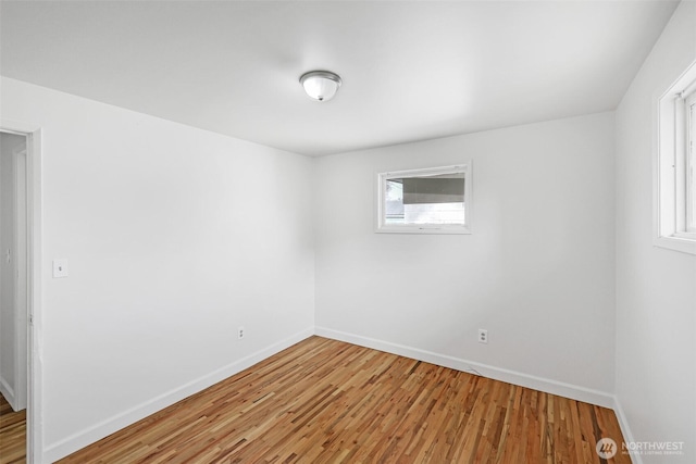 unfurnished room featuring baseboards and light wood-style floors