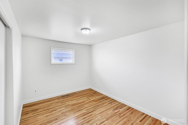 spare room with light wood-style flooring and baseboards