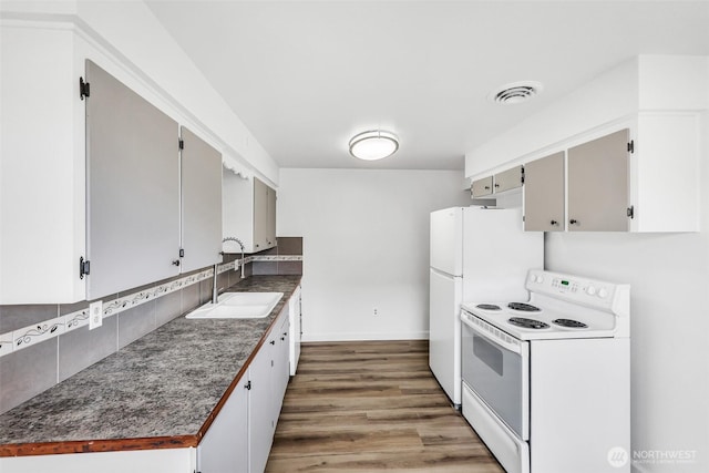 kitchen with visible vents, white electric range, a sink, tasteful backsplash, and wood finished floors