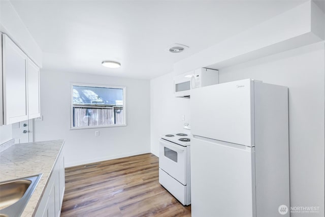 kitchen with visible vents, light wood-style flooring, white appliances, white cabinets, and light countertops