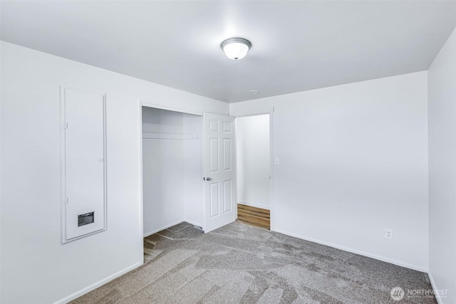 unfurnished bedroom featuring a closet, carpet floors, and baseboards