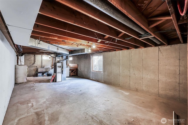 below grade area featuring water heater and a sink