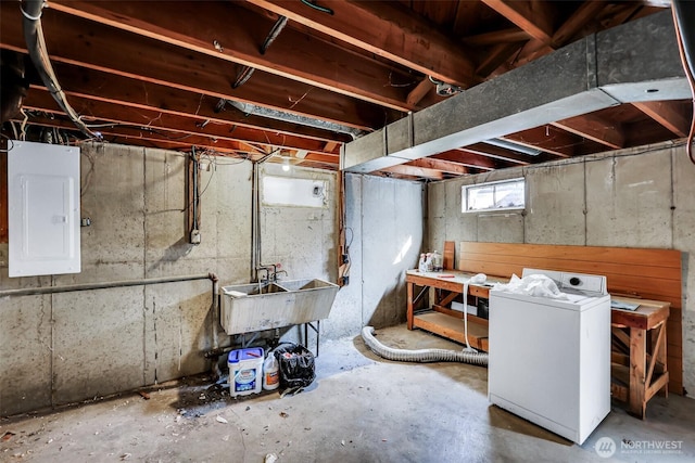 below grade area featuring washer / dryer, electric panel, and a sink