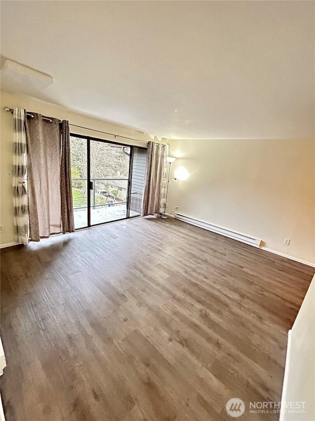 interior space with baseboards, baseboard heating, and wood finished floors