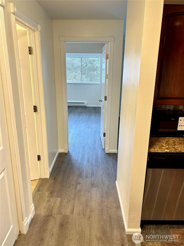 corridor featuring baseboard heating, baseboards, and dark wood-style flooring