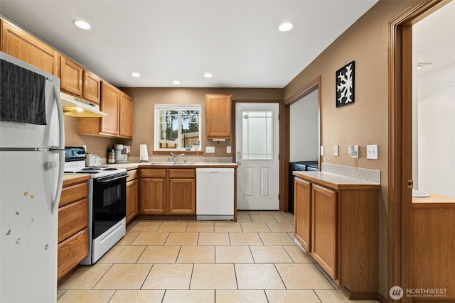 kitchen with under cabinet range hood, a sink, recessed lighting, white appliances, and light countertops