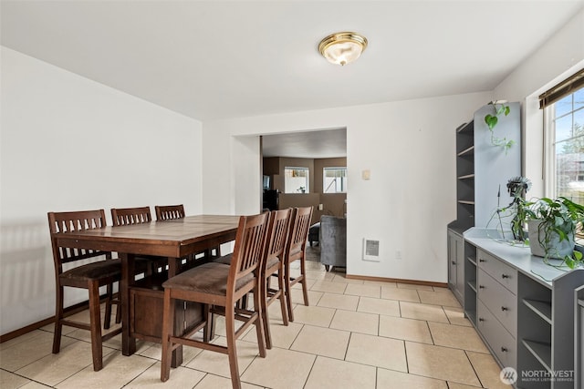 dining area featuring light tile patterned floors, visible vents, and baseboards