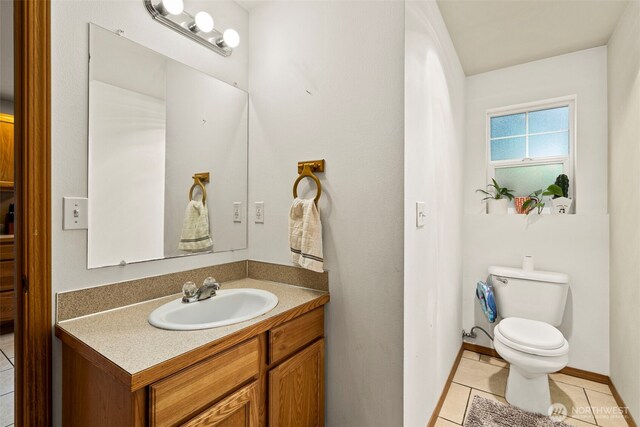 bathroom featuring tile patterned flooring, toilet, and vanity