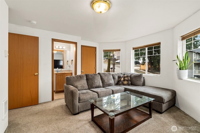 living area featuring light carpet