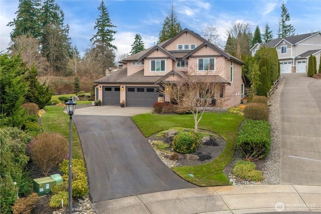 craftsman house featuring driveway, a front lawn, and board and batten siding