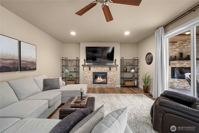 living area featuring recessed lighting, a fireplace, and wood finished floors