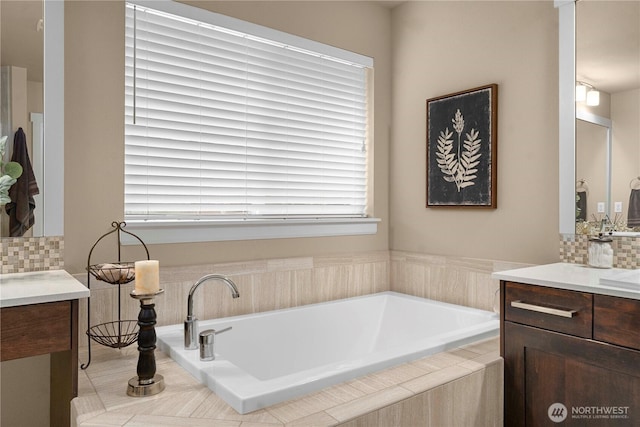 full bathroom featuring tasteful backsplash, a bath, and vanity