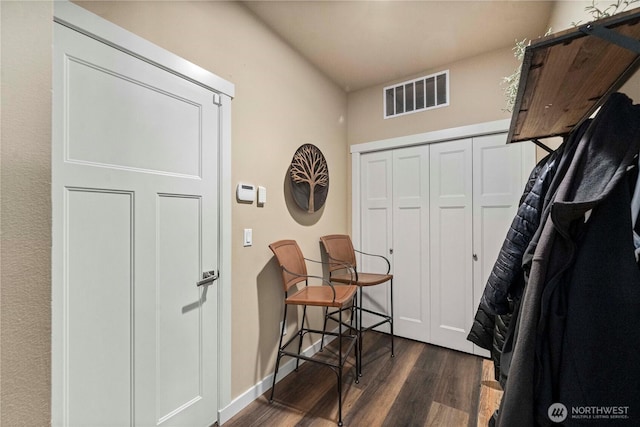 foyer with visible vents, baseboards, and dark wood-style flooring