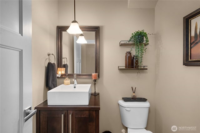 half bathroom with vanity and toilet