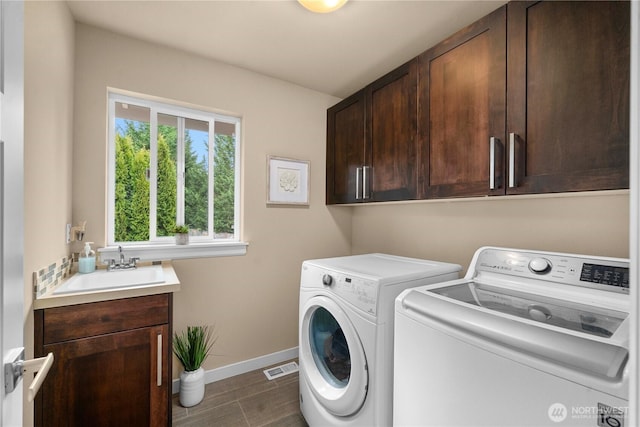 laundry room with visible vents, washer and dryer, a sink, cabinet space, and baseboards