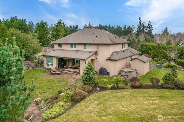 back of property with fence, a lawn, and a patio area