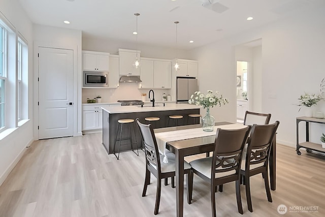 dining room featuring recessed lighting, light wood-style flooring, and baseboards