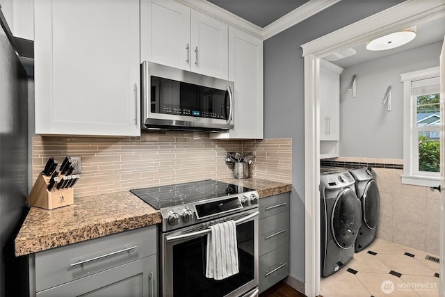 kitchen with crown molding, gray cabinets, white cabinets, independent washer and dryer, and stainless steel appliances