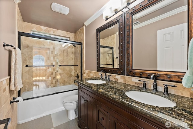 full bathroom featuring tile walls, crown molding, and a sink