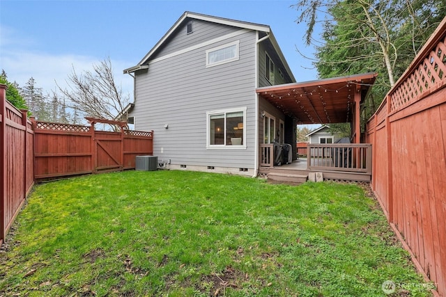 rear view of property featuring crawl space, a lawn, central AC unit, and a fenced backyard