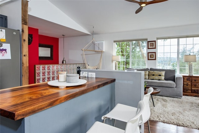 bathroom featuring backsplash, ceiling fan, lofted ceiling, and wood finished floors